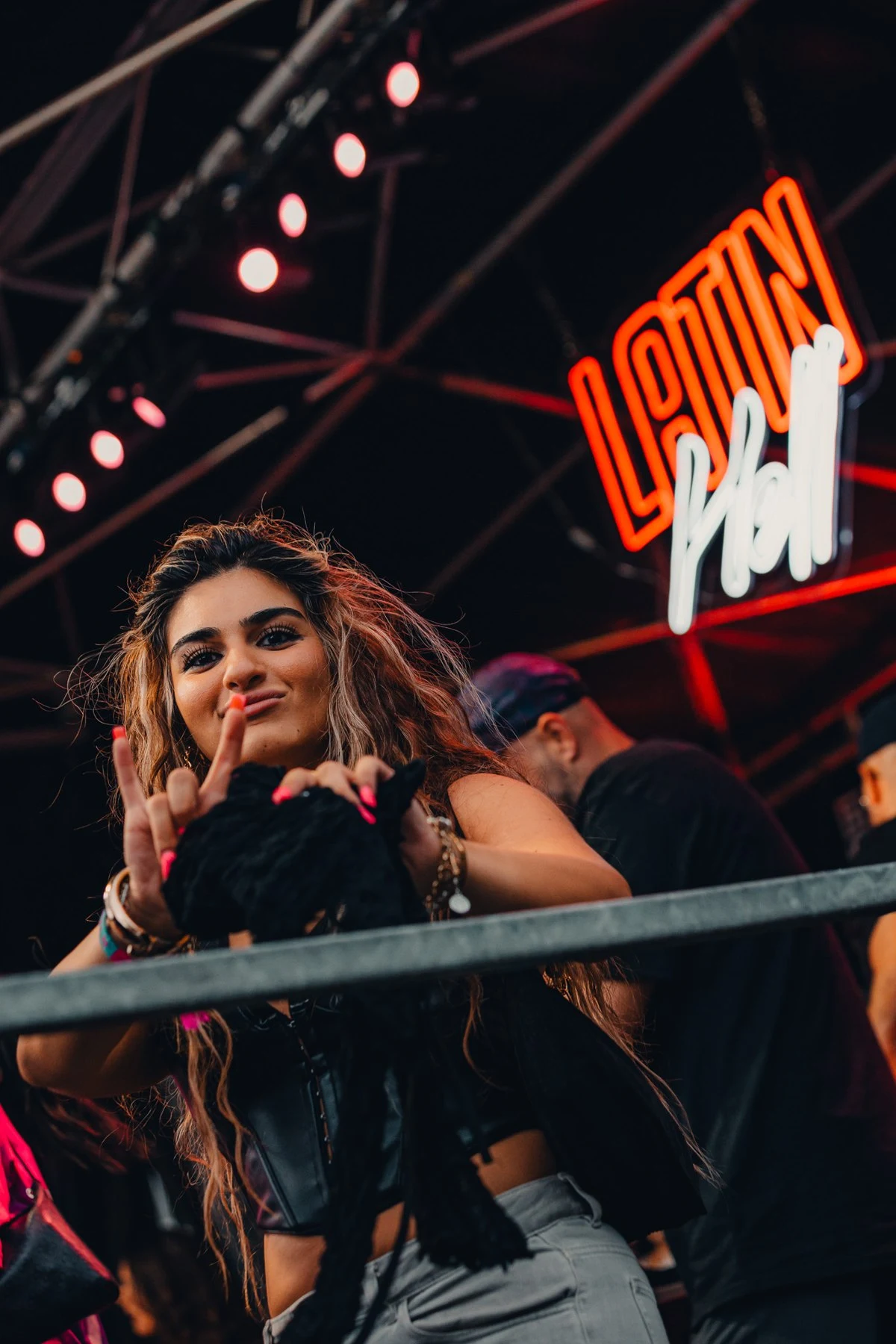 Besucherin vor dem leuchtenden Latin Hell Logo beim Karneval der Kulturen